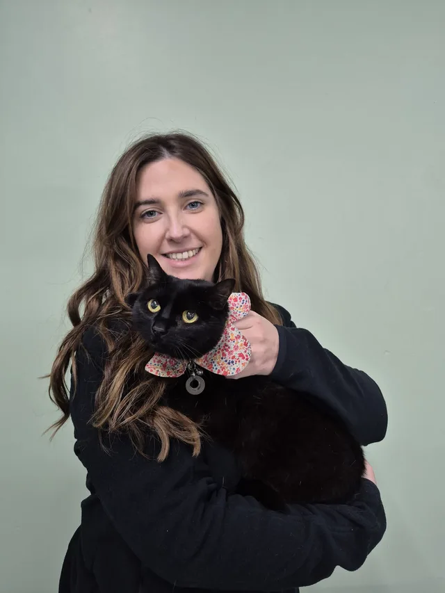 Woman holding a black cat